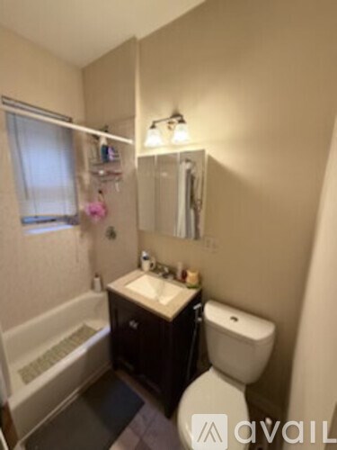 A bathroom with a toilet, sink, and bathtub.
