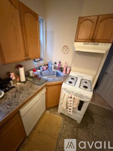 A kitchen with wooden cabinets and a white dishwasher.