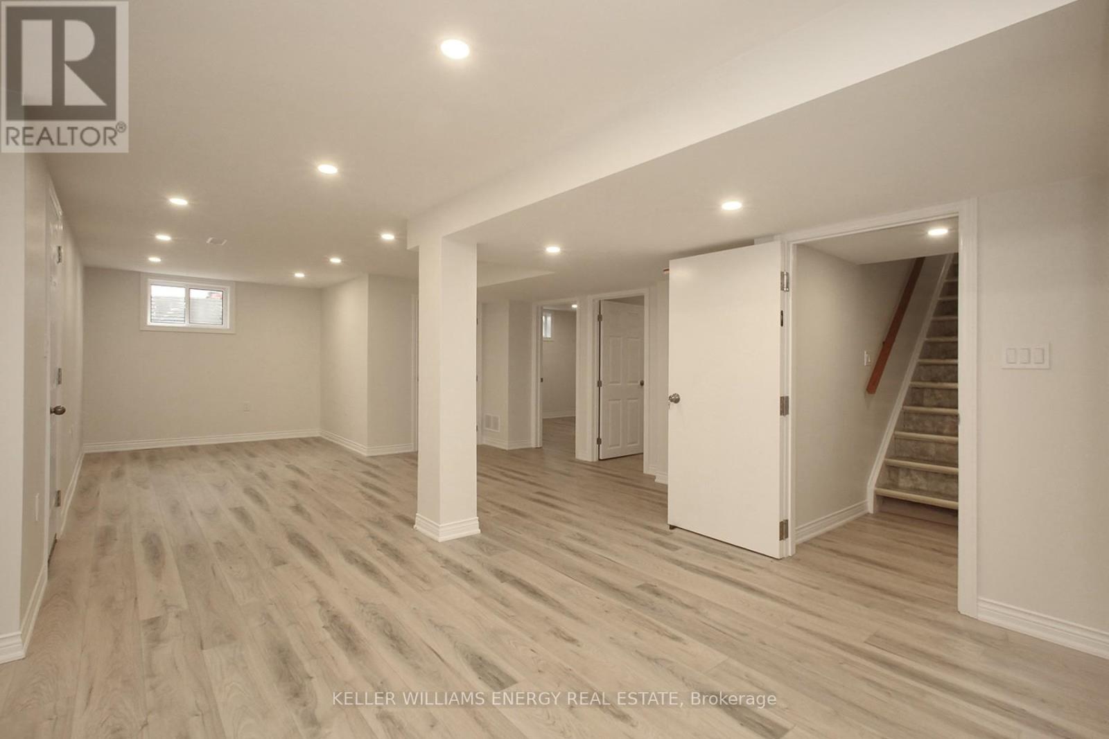 A spacious room with a staircase leading to another room.