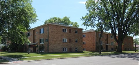 A large brick building with a tree in front of it.