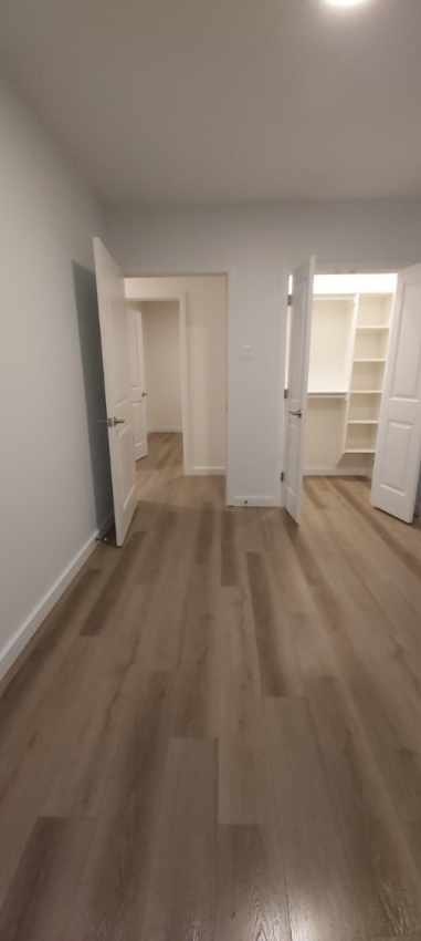 A room with wooden flooring and white walls.