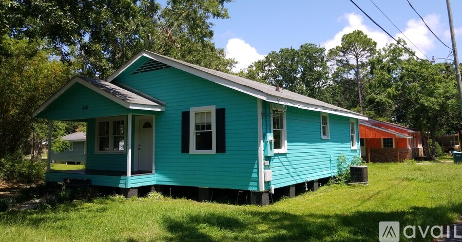 A blue house with a white door and windows is in front of a red house.