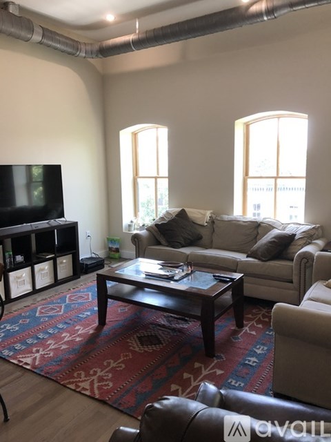 A living room with a couch, a coffee table, and a television.