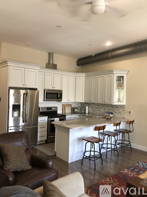 A kitchen with white cabinets and a refrigerator.