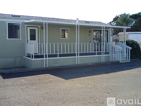 A mobile home with a porch and a white railing.