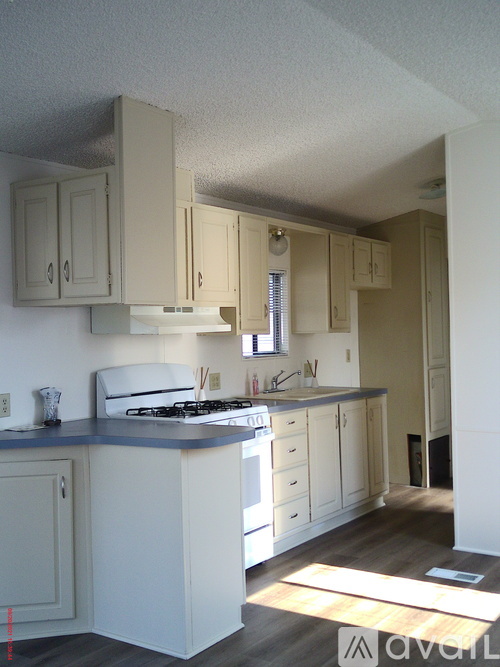 A kitchen with white cabinets and a blue counter.
