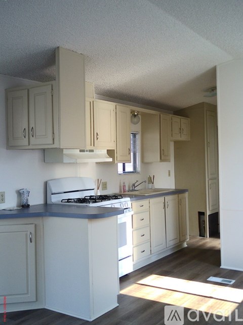 A kitchen with white cabinets and a blue counter.