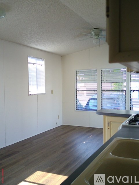 A kitchen with a sink and a window with blinds.