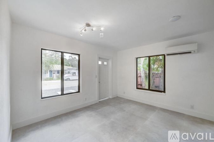 A spacious room with a window and a door.