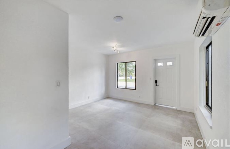 A spacious, empty room with a window and a door.