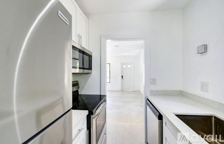 A modern kitchen with white appliances and a black countertop.
