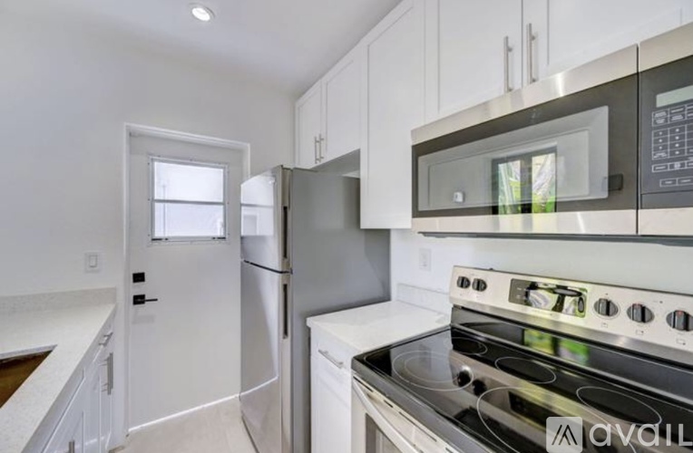 A modern kitchen with white cabinets and stainless steel appliances.