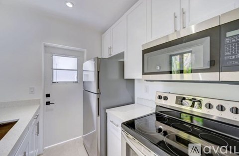 A modern kitchen with white cabinets and stainless steel appliances.