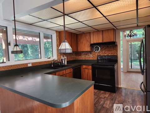 A kitchen with wooden cabinets and a black oven.