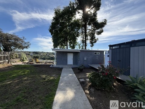 A modern house with a concrete pathway leading to the front door.