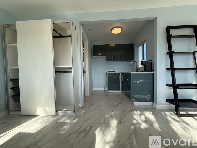 A kitchen with a white refrigerator and a wooden ladder.