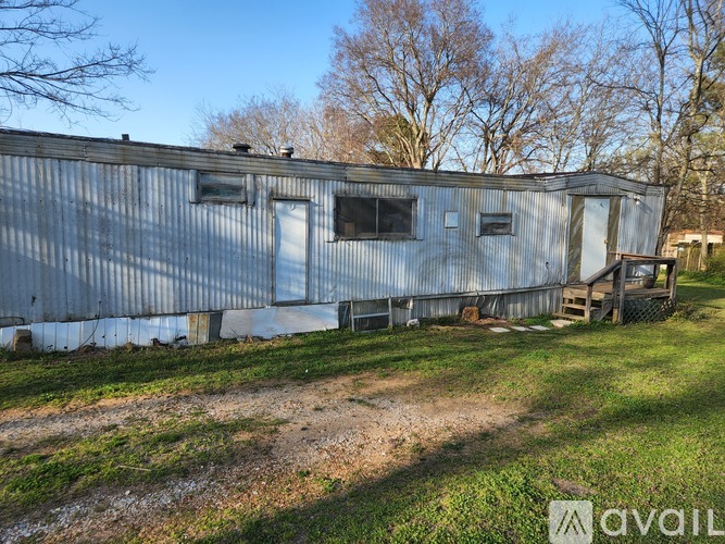 A large metal building with a dirt path in front of it.