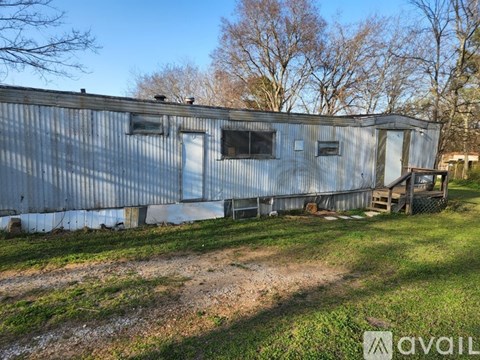 A large metal building with a dirt path in front of it.
