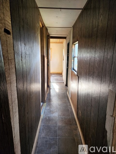 A long hallway with wooden walls and tile flooring.