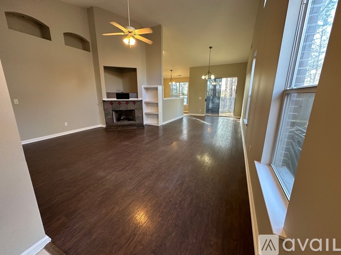 A spacious living room with wood flooring and a ceiling fan.