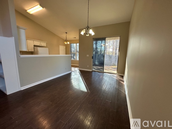 A spacious room with wooden floors and a large window.