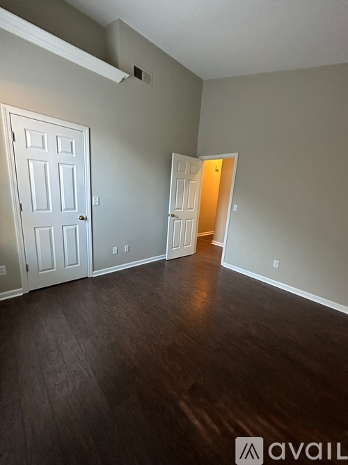 A room with a white door and a wooden floor.