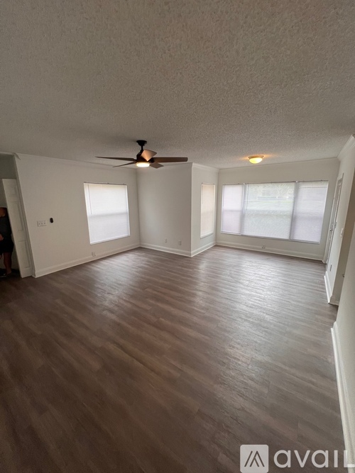 A room with wooden flooring and a ceiling fan.