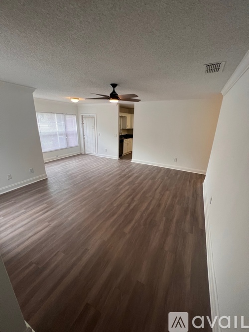A room with wooden flooring and a ceiling fan.