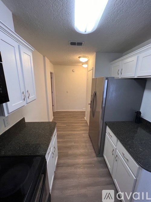 A kitchen with black countertops and white cabinets.