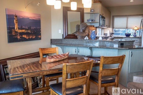 A kitchen with a dining table and chairs.