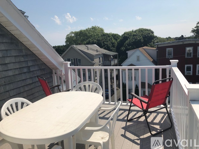 A white table and chairs are on a white deck.
