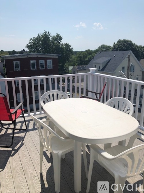 A white plastic table and chairs on a deck.