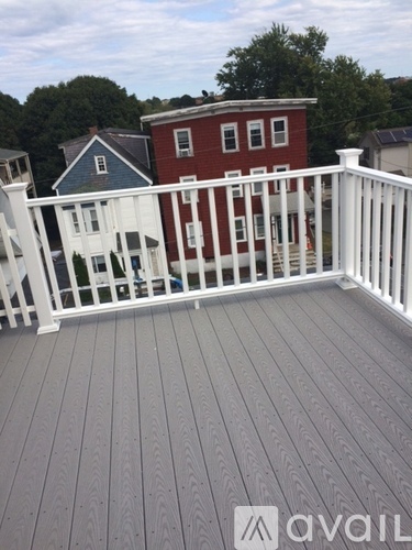 A deck with a white railing and a grey floor.
