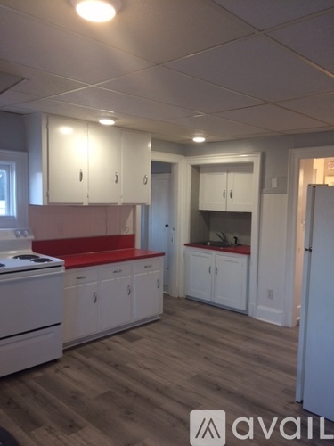A kitchen with white cabinets and a wooden floor.