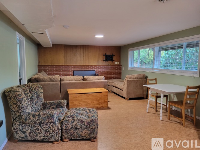 A living room with a couch, chairs, and a TV.