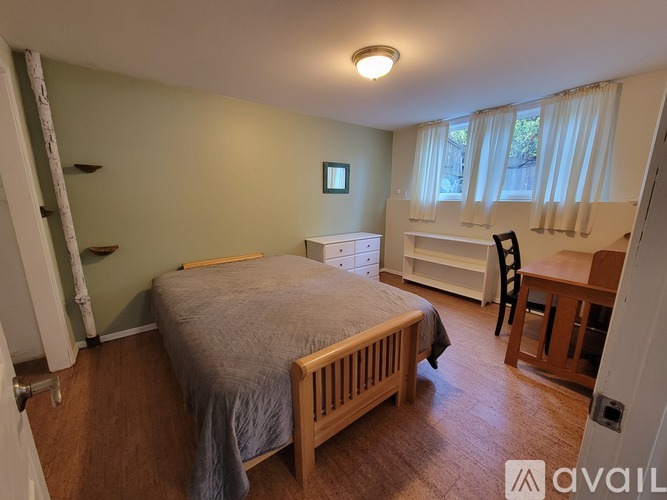 A bedroom with a bed, desk, and chair.