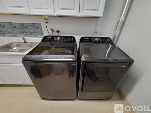 Two front loading washing machines in a kitchen.