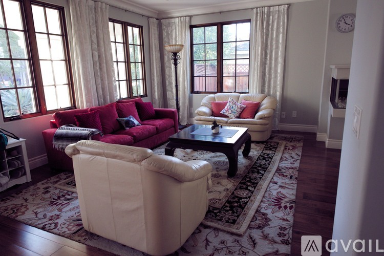 A living room with a red couch and a beige armchair.