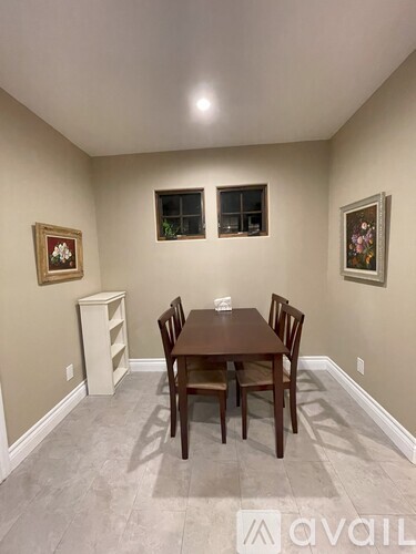 A dining room with a table and chairs.
