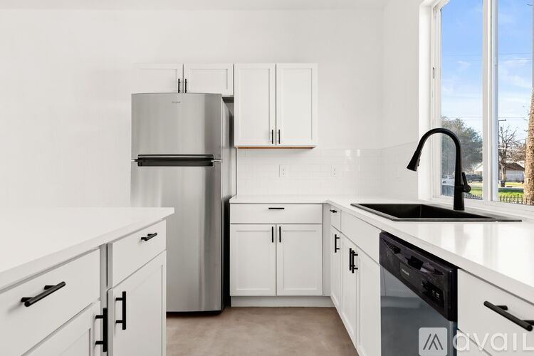 A kitchen with white cabinets and appliances.