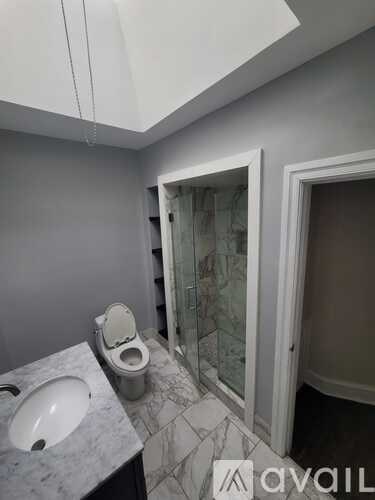 A bathroom with a toilet, sink, and shower.