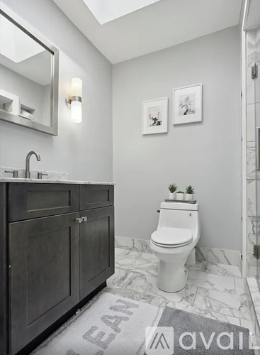 A bathroom with a white toilet and a grey cabinet.