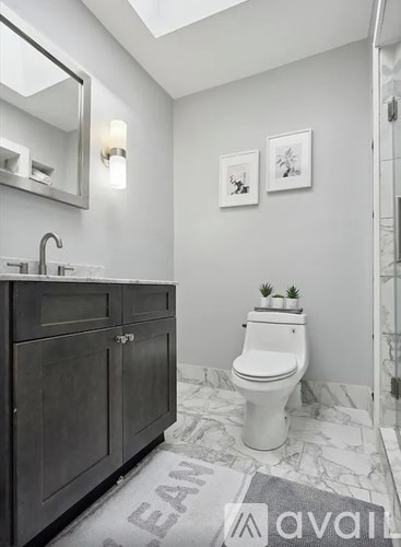 A bathroom with a white toilet and a grey cabinet.
