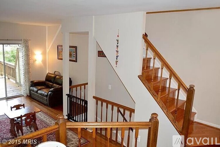 A living room with a couch, a table, and a staircase.