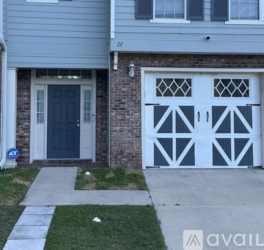 A house with a blue door and a garage door with a diamond pattern.