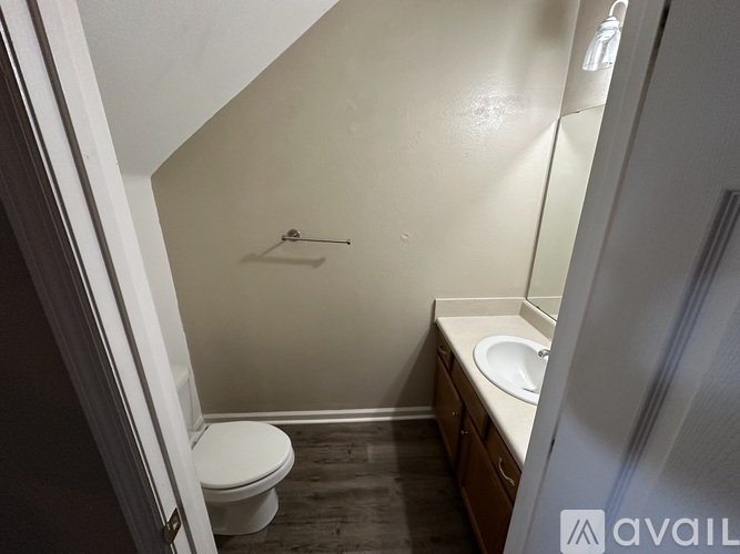 A small bathroom with a toilet, sink and shower.