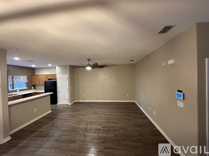 A spacious room with a ceiling fan and a wall-mounted air conditioning unit.