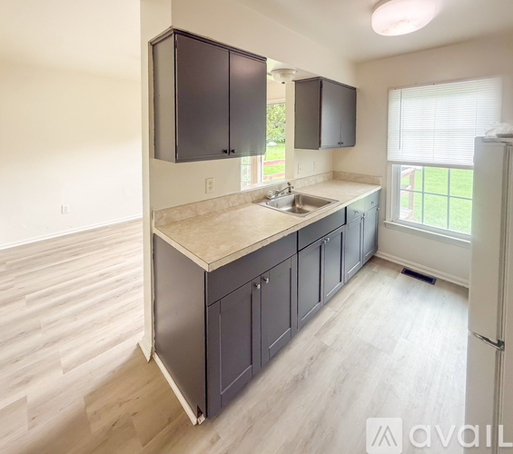 A kitchen with dark cabinets and a white fridge.
