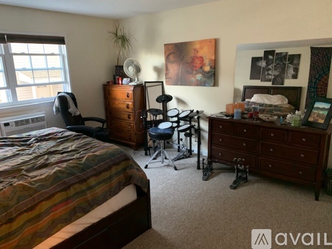 A bedroom with a bed, dresser, and chair.