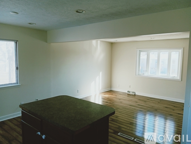 A room with a brown desk and a window with blinds.